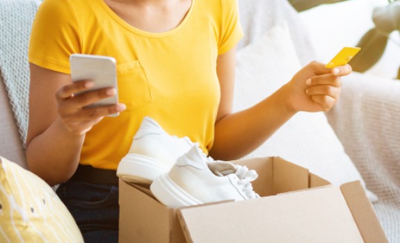 Jeune femme qui découvre son achat commandé sur internet Jeune femme qui découvre son achat commandé sur internet